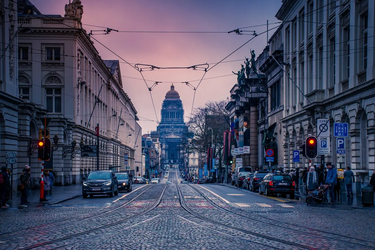 Ulica w centrum Brukseli o zmierzchu z widokiem na kopułę Pałacu Sprawiedliwości